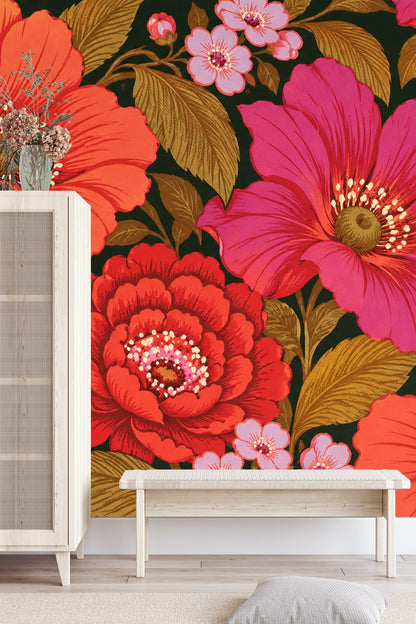 Bedroom scene with bold coral and magenta floral wallpaper behind white upholstered bed and wooden bedside table