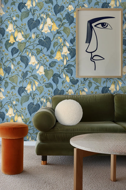 Living room wall covered in botanical wallpaper with hanging chair and neutral cushions
