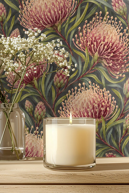 Detailed view of crimson and blush pincushion protea flowers with green leaves on charcoal background wallpaper.