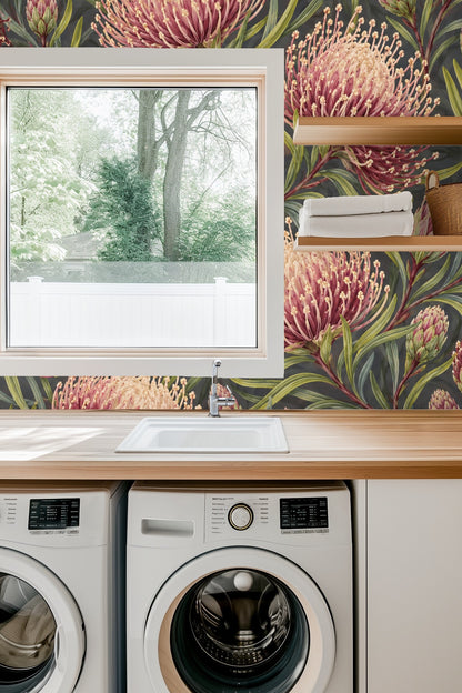 Close-up of lit candle and delicate flowers in front of crimson pincushion floral wallpaper.