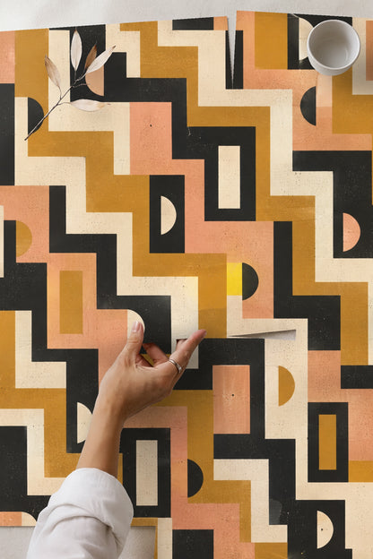 Lifestyle image of Mid-Century Mod Geometry wallpaper behind green mid-century style chair with wood armrests and striped pillow
