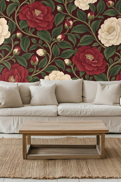 Living room scene with orange velvet sofa in front of wallpaper with large burgundy and cream camellia flowers and green leaves against a cl