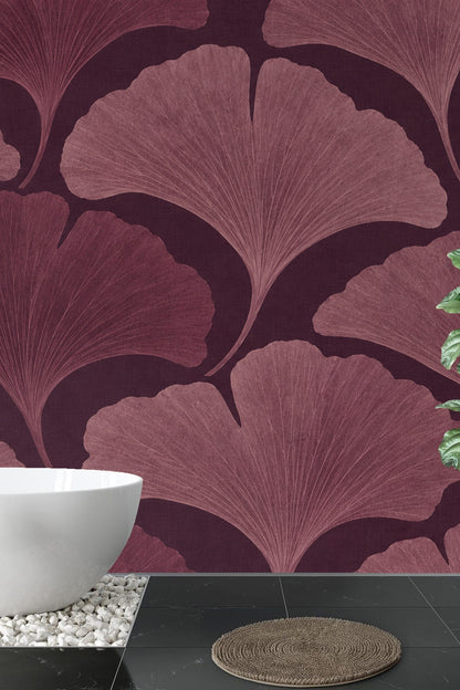 Living space wall segment covered in rich plum ginkgo leaf wallpaper, with floor molding