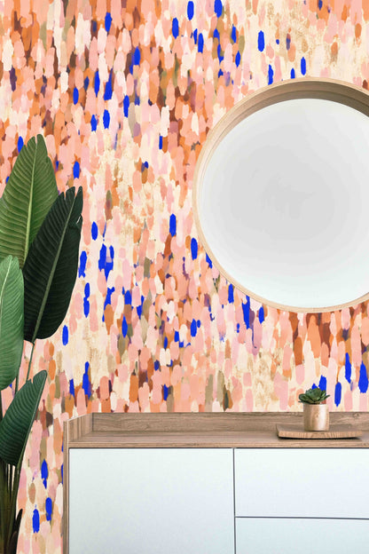 Soft coral and peach wallpaper with cobalt blue brushstroke accents on a living room wall