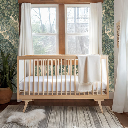 Vaulted bedroom with the wallpaper covering the gable wall behind a simple wood bed and windows