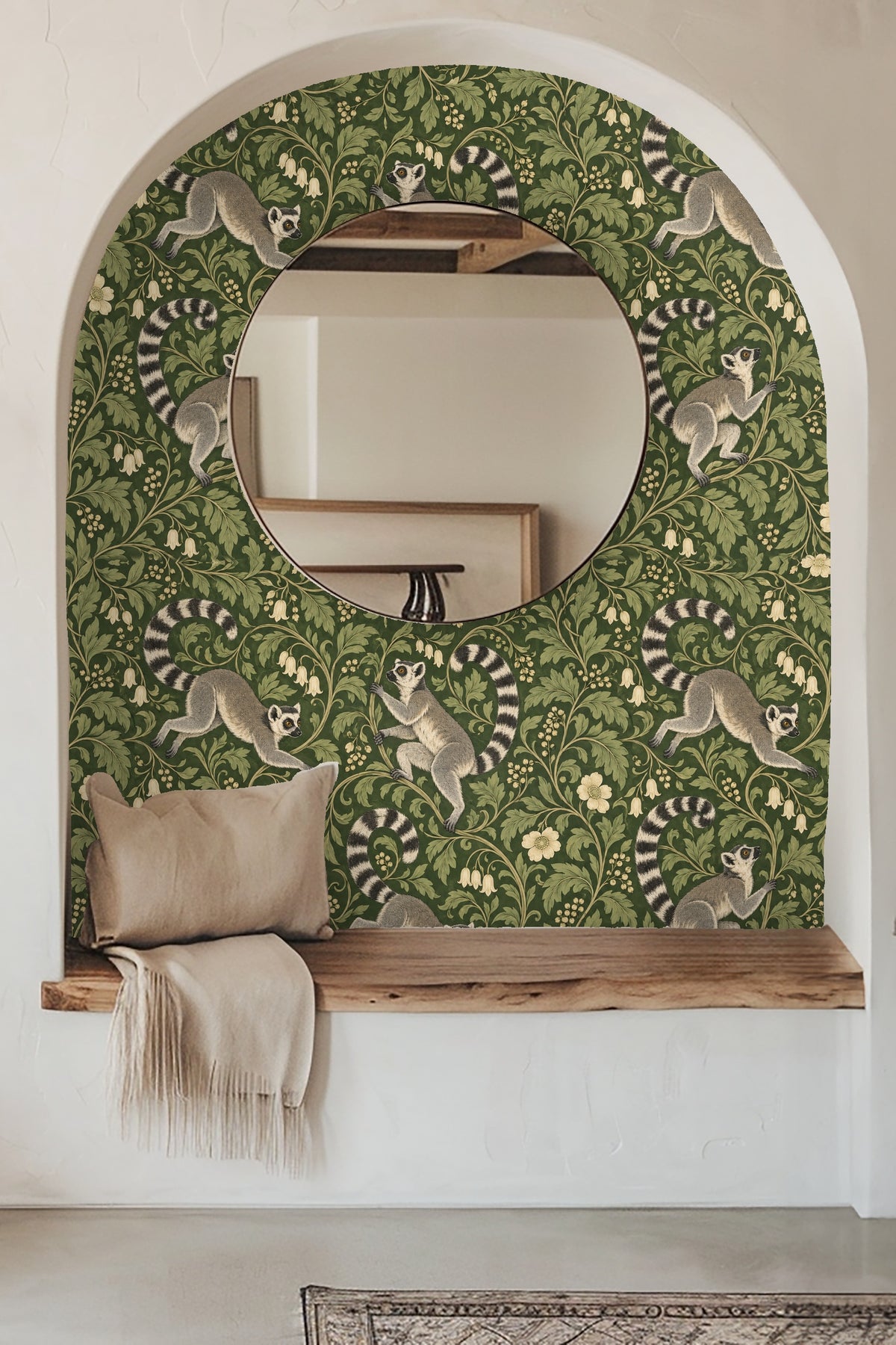Bathroom sink and mirror with brass fixtures featuring wallpaper with playful lemurs amid lush green foliage