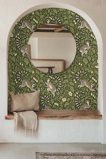 Bathroom sink and mirror with brass fixtures featuring wallpaper with playful lemurs amid lush green foliage