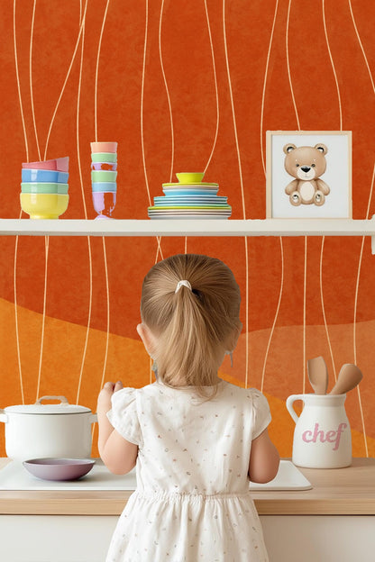 Wallpaper applied on nursery wall with rocking chair and soft pouf in foreground