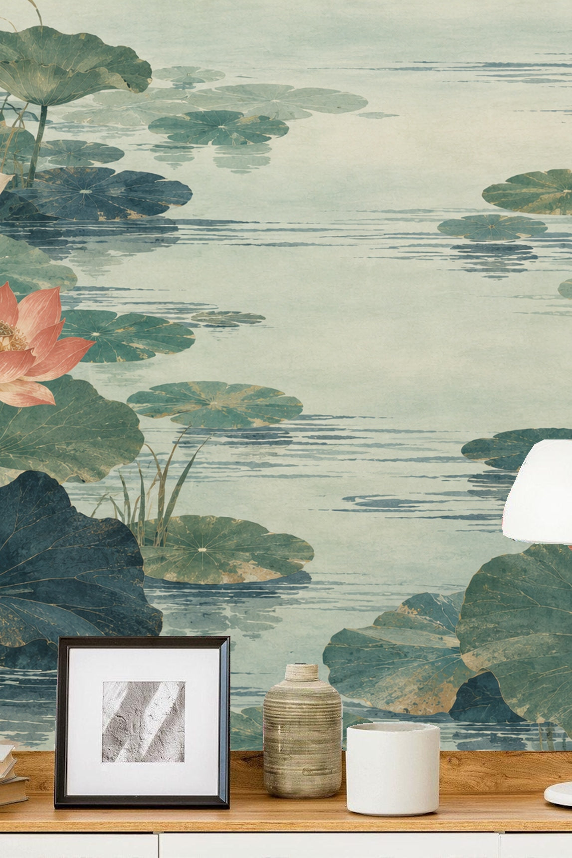 Water surface with lotus leaves casting reflections in gentle blue-green hues.