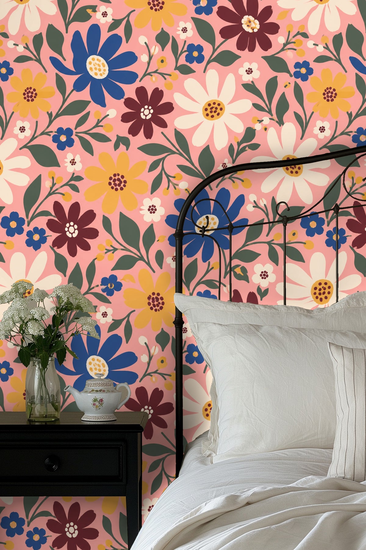 Living room with white curved sofa and red armchair featuring bold floral wallpaper in pink, blue, white, and yellow tones