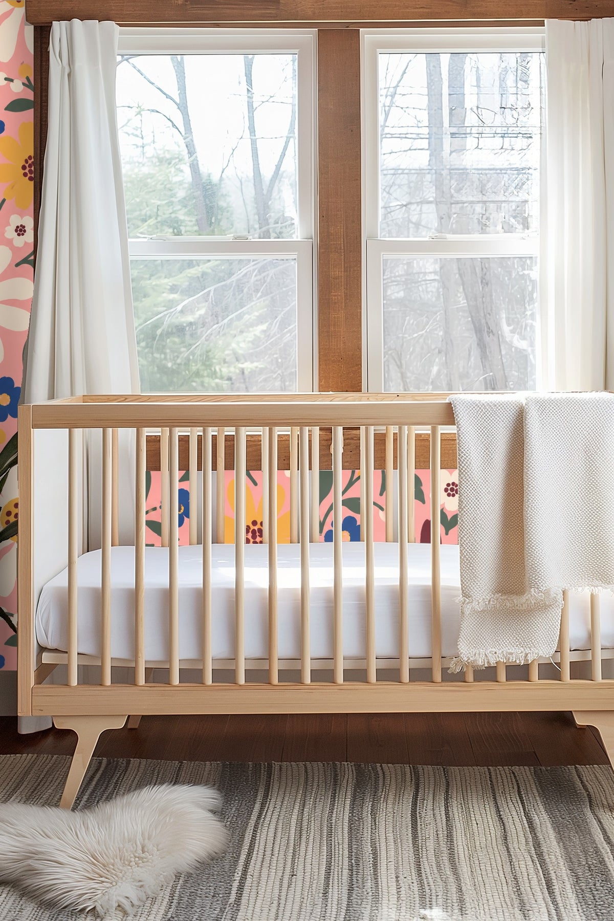 Bedroom wall behind an iron headboard covered with vibrant folk-inspired floral wallpaper with pink background