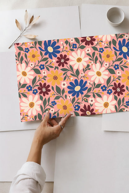 Detailed shot of mustard flowers with dotted centers on pink wallpaper