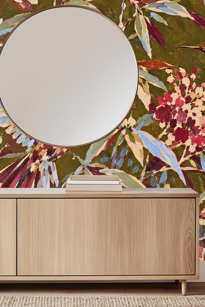 Clusters of pink and cream blossoms interspersed with long blue and olive leaves in wallpaper
