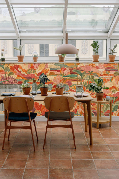 Multiple blooming flowers in warm palette resembling stitched textile on wallpaper