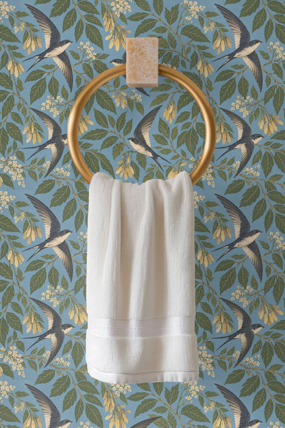 Close-up of wallpaper showing detailed swallow wing patterns and botanical elements in muted blue, green, and yellow hues