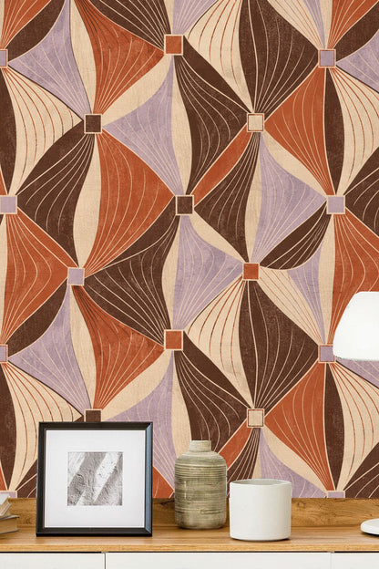 Swatch detail of folded ribbon motif in warm brown and terracotta on textured cream background.