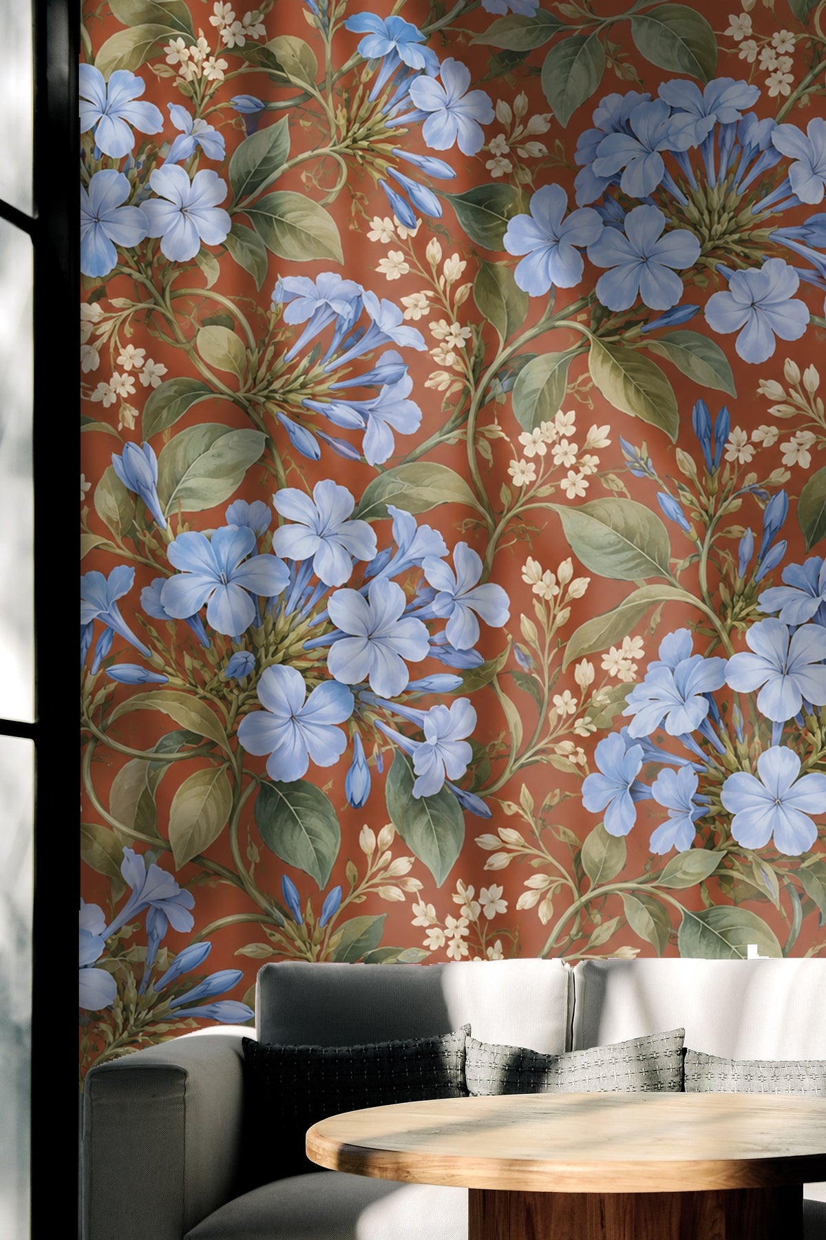 Floral wallpaper roll unrolled displaying blue plumbago flowers against burnt orange ground