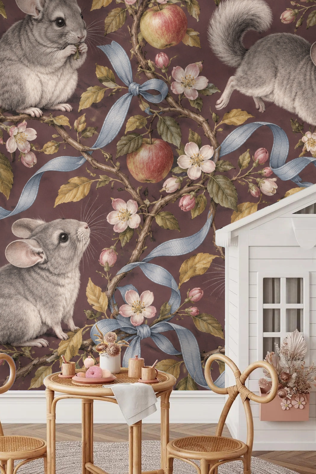 Close-up view of gray chinchilla perched on branch near apple blossoms and blue ribbon.