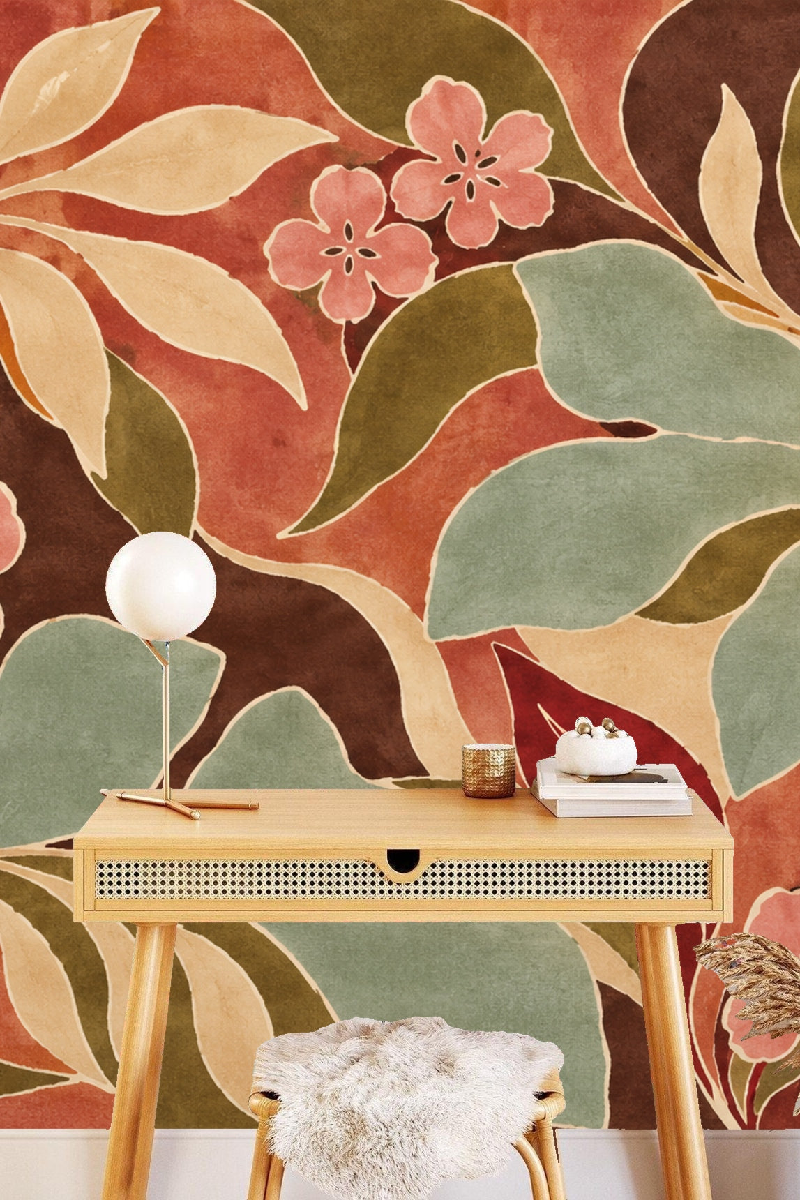 Section of wallpaper illustrating large sculptural leaves in muted green and cream hues intertwined with soft pink flowers.