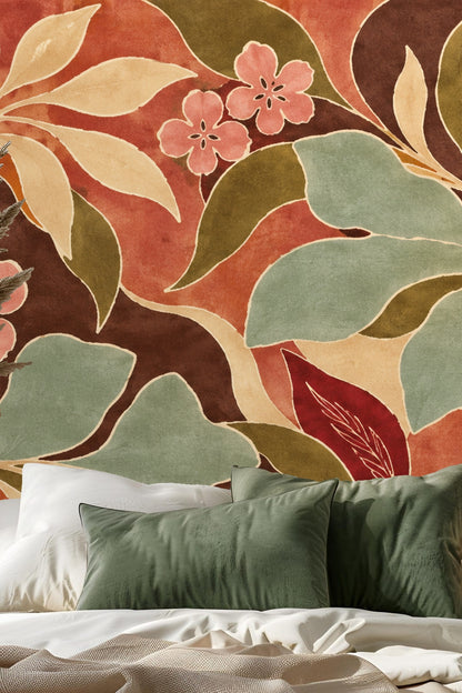 Living room wall covered in bold floral wallpaper featuring flowing leaves and pink blossoms behind a neutral-toned sofa with textured throw