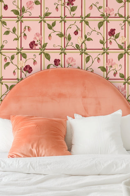 Living room with blush trellis sweet pea wallpaper behind orange sofa and patterned rug