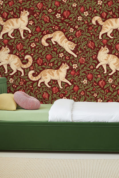 Living room featuring wallpaper with creamy ginger cats, pomegranates, and lush greenery behind a curved pink velvet sofa