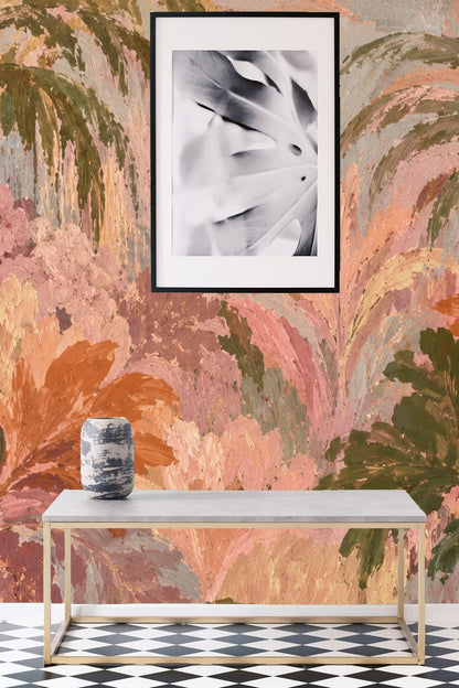 Workspace with warm peach and olive green palm wallpaper behind desk and plants