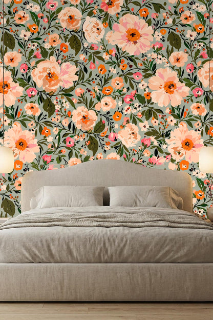 Nursery room with peach floral wallpaper behind wooden crib and cream armchair