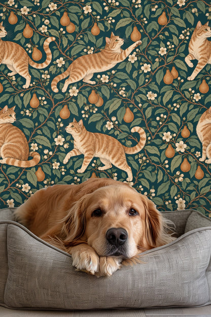 Close-up of a lit candle and white flowers in front of wallpaper with orange tabby cats and blossoming pear branches