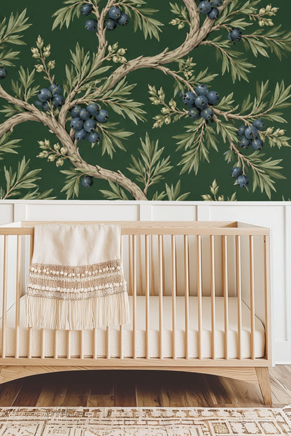 Bedroom scene with coral velvet headboard against deep green Juniper Grove wallpaper featuring detailed juniper branches and berries.