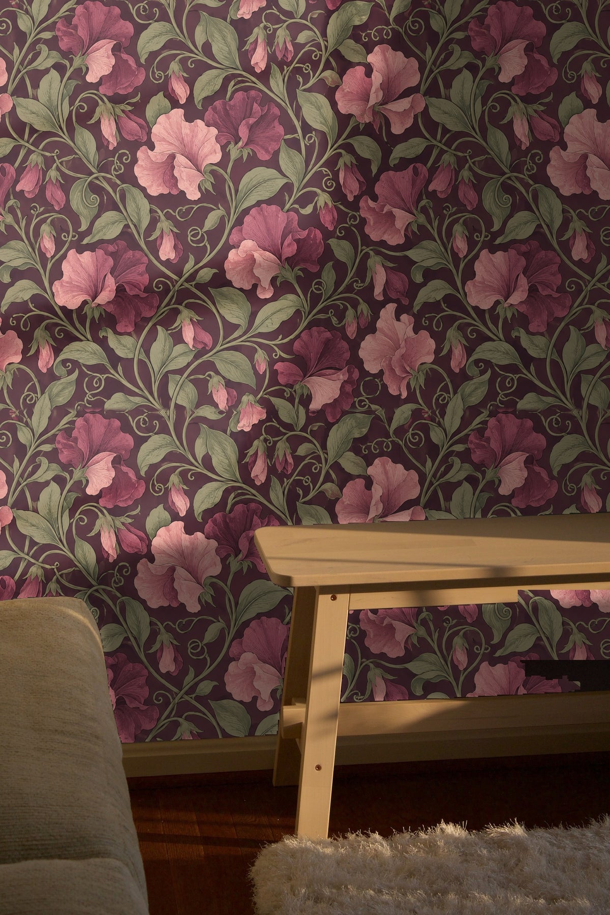 Velvet blue couch in front of wallpaper with richly colored botanical sweet pea pattern