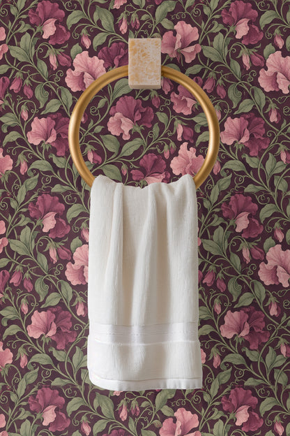 Muted green leaves curling delicately around soft pink and purple blossoms on wallpaper