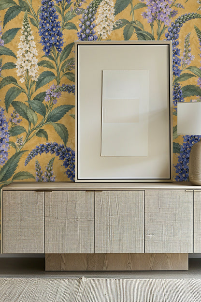 Close-up of bathroom wall wallpaper showing detailed blue and white delphinium flowers with green foliage on textured mustard backdrop, with
