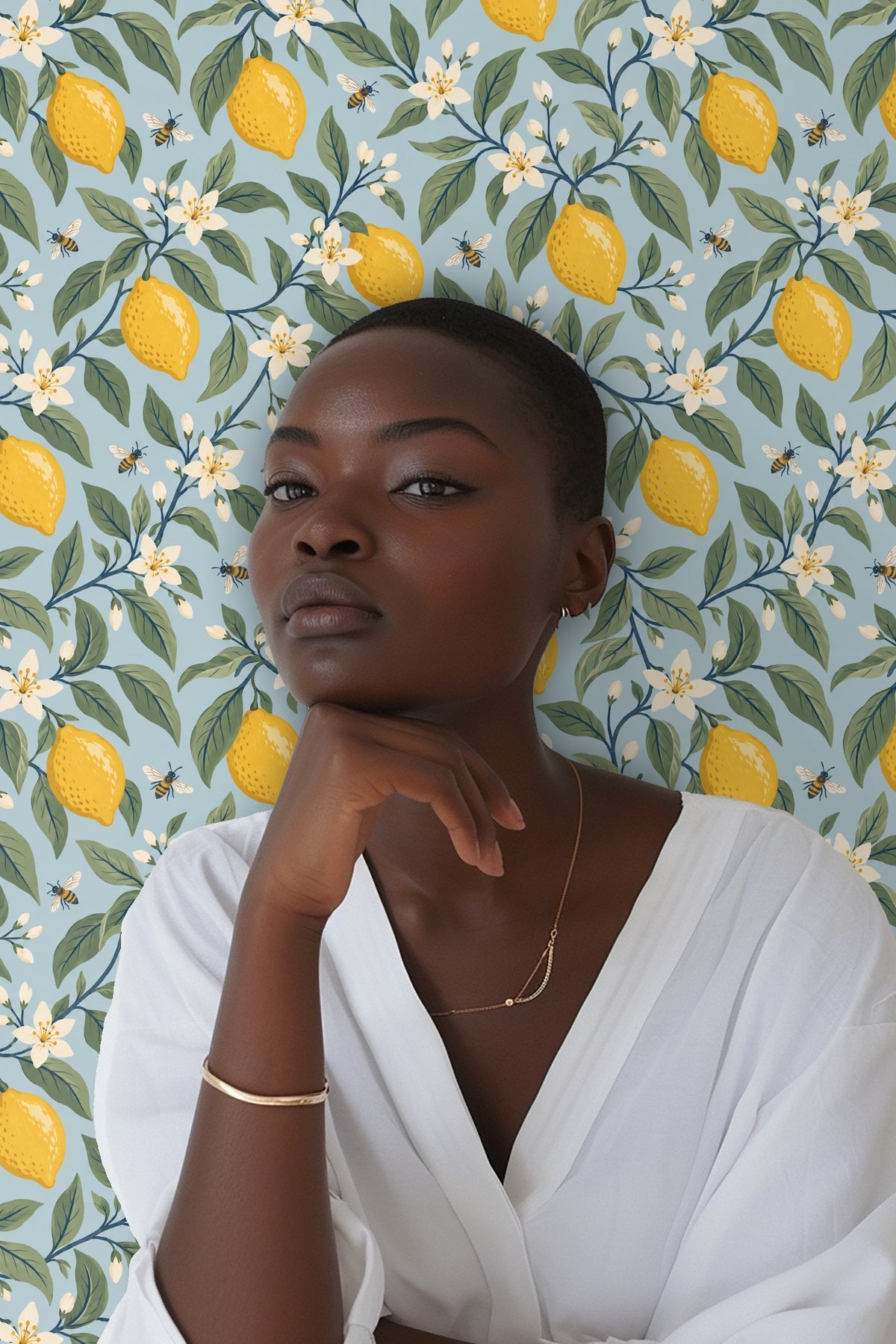 green leaves and yellow lemons intertwined on vibrant blue wallpaper