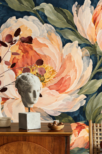 Peony Bloom on Indigo wallpaper covering an accent wall behind a beige sectional sofa and gold coffee table in a living room