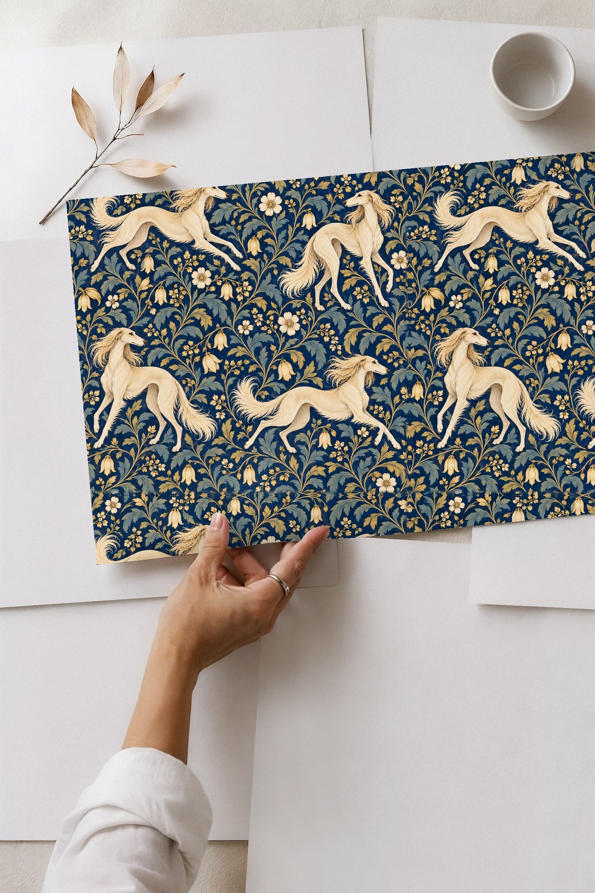 Washer and dryer under countertop with floral and dog wallpaper above.