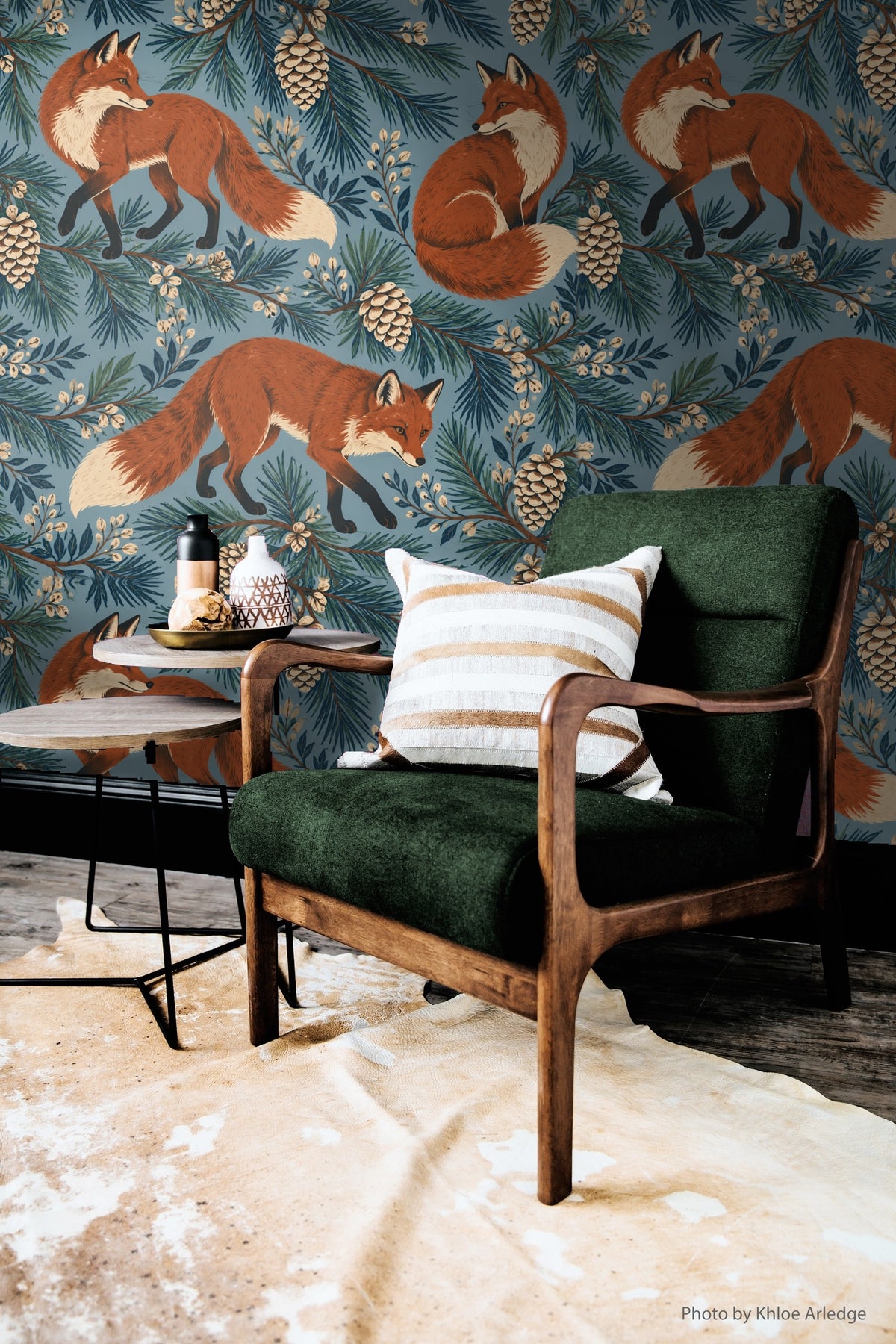 Hand showing a printed wallpaper sheet with forest motif.