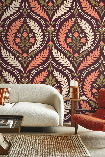 Living room with terracotta foliage damask wallpaper behind cream sofa and red chair