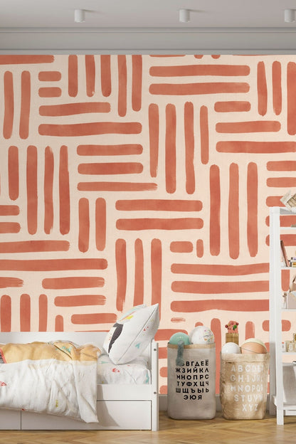 Living room corner with soft gray armchair against a wall covered in terracotta linear grid wallpaper