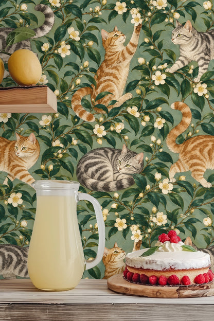 Orange tabby cat standing in profile on wallpaper filled with dense floral and feline motifs.