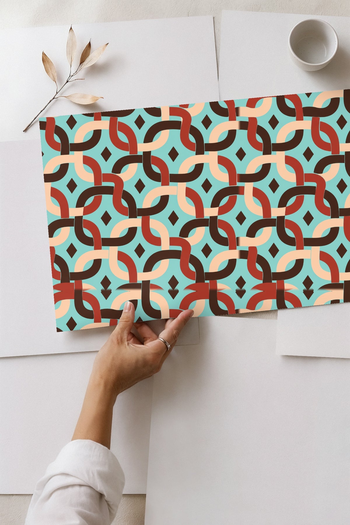Close-up detail of interwoven curved bands in brown, rust, and beige on aqua