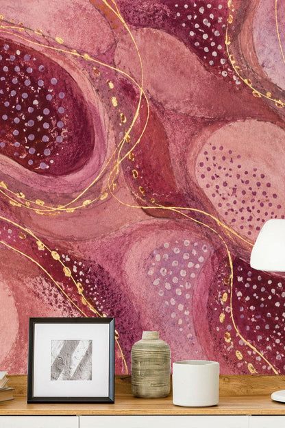 Child's room corner with playful pink and plum abstract wallpaper backdrop and a wooden chair with antler design