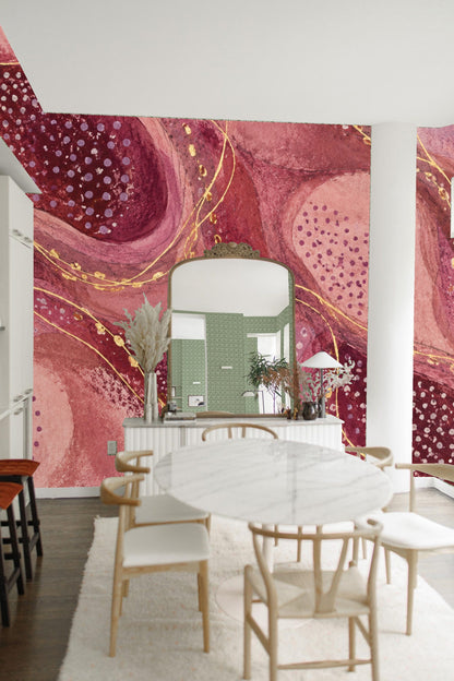 Close-up of rounded, layered shapes in plum and pink tones with dotted patterns and gold lines
