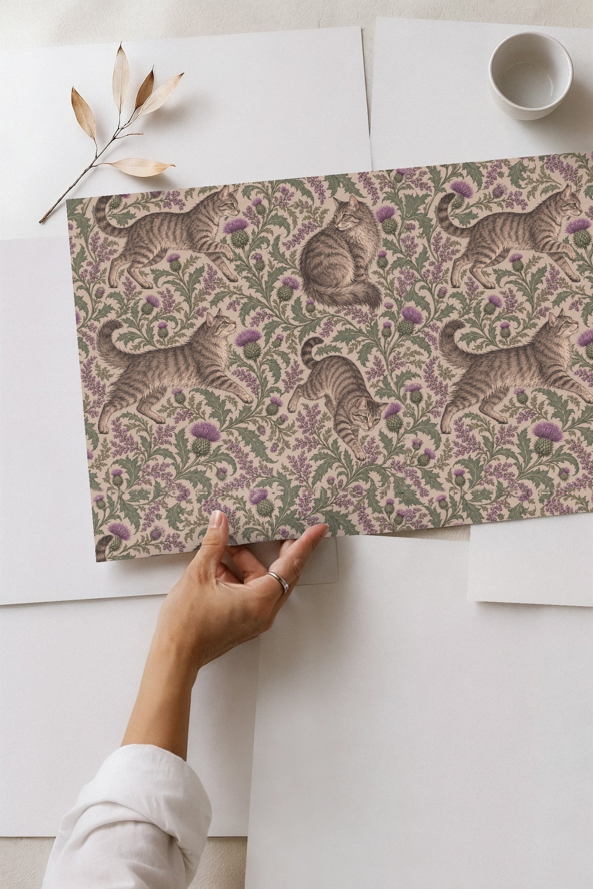 Cluster of blooming purple thistles with serrated green leaves on wallpaper