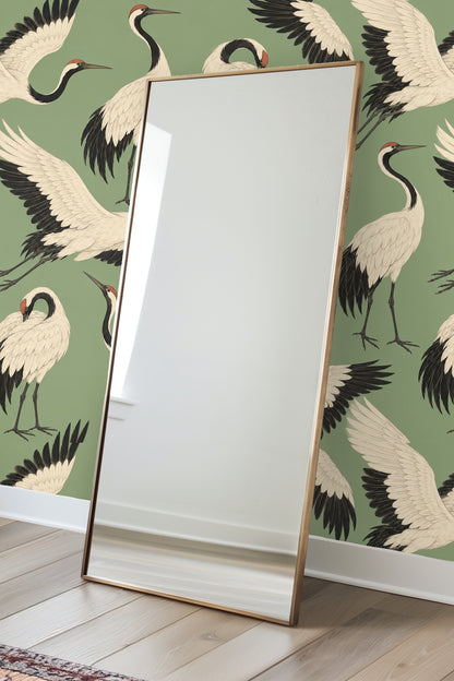 Section of wallpaper showing multiple white cranes in various poses on muted green background.