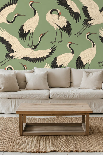 Close-up detail of white cranes with black wings and red crowns on sage green background wallpaper.