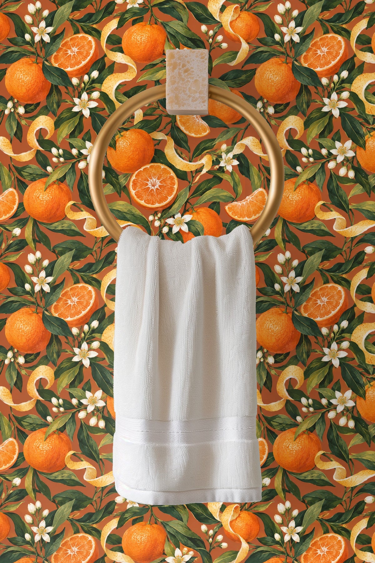 Full orange with dimpled skin surrounded by glossy green leaves and white blossoms