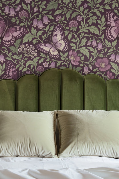 Bedroom wall featuring violet butterfly wallpaper behind olive green velvet headboard and white pillows