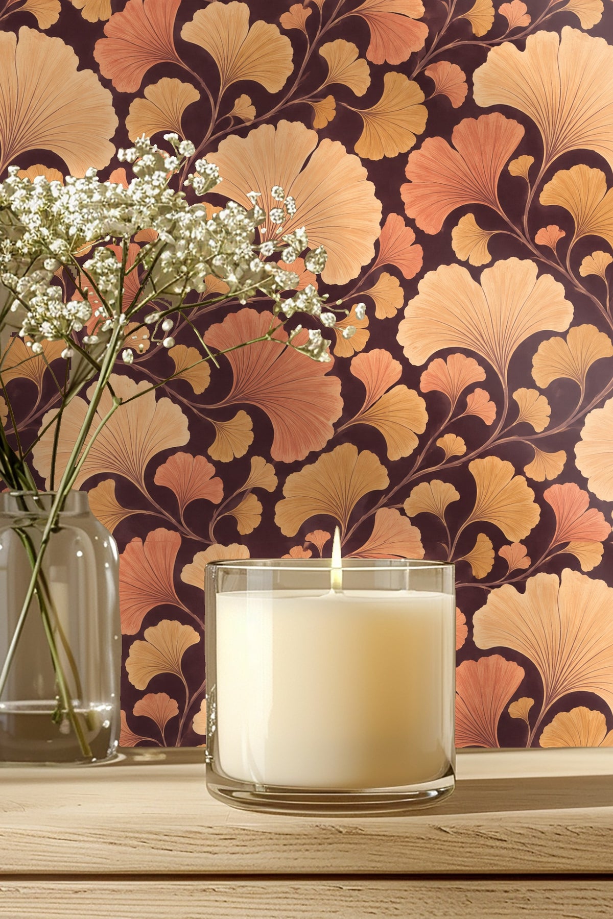 Bathroom medicine cabinet mounted on wall covered with ginkgo leaf wallpaper in warm orange and gold hues.