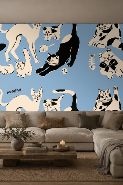 Group of kittens in black and cream on blue wallpaper pattern